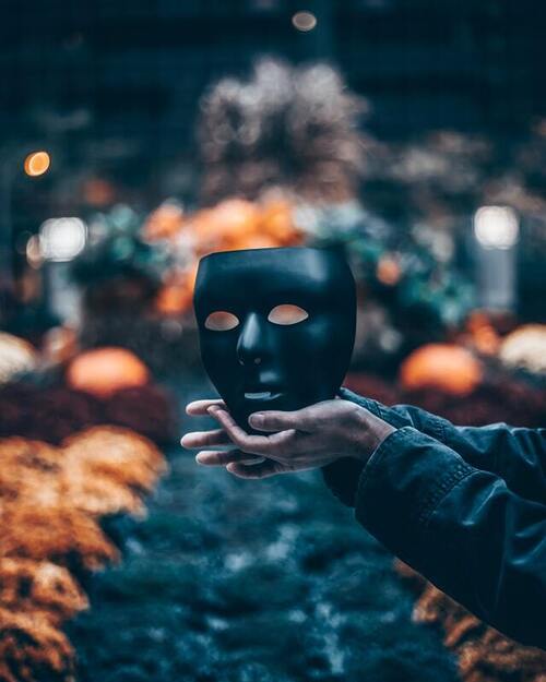 Person holding black mask