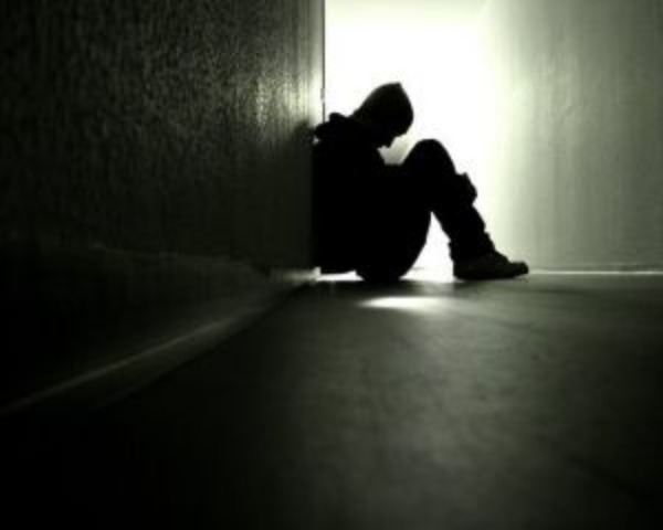 man sitting on floor against wall